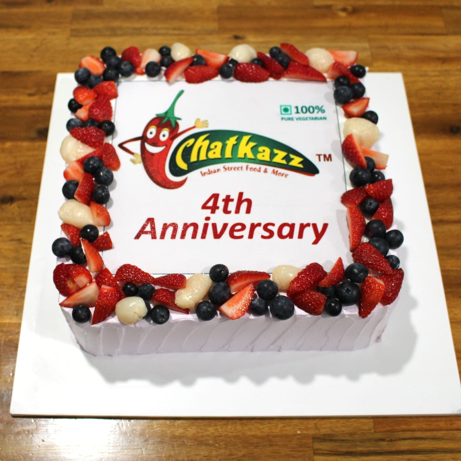 Custom cake with corporate anniversary fruit tier detail — Angel Bakes, Adelaide