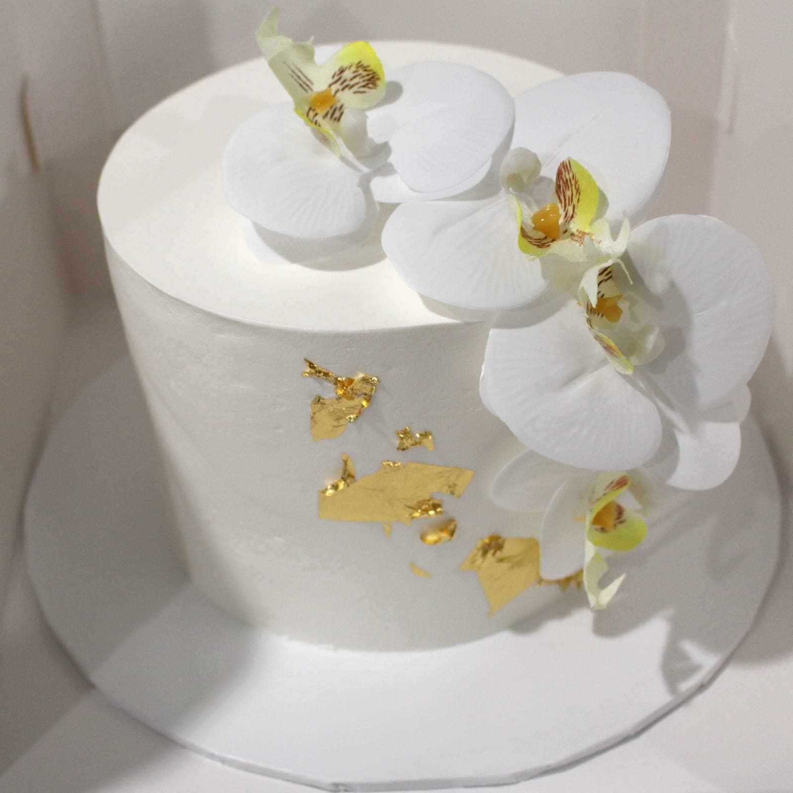 Custom cake with white orchid gold leaf tier detail — Angel Bakes, Adelaide