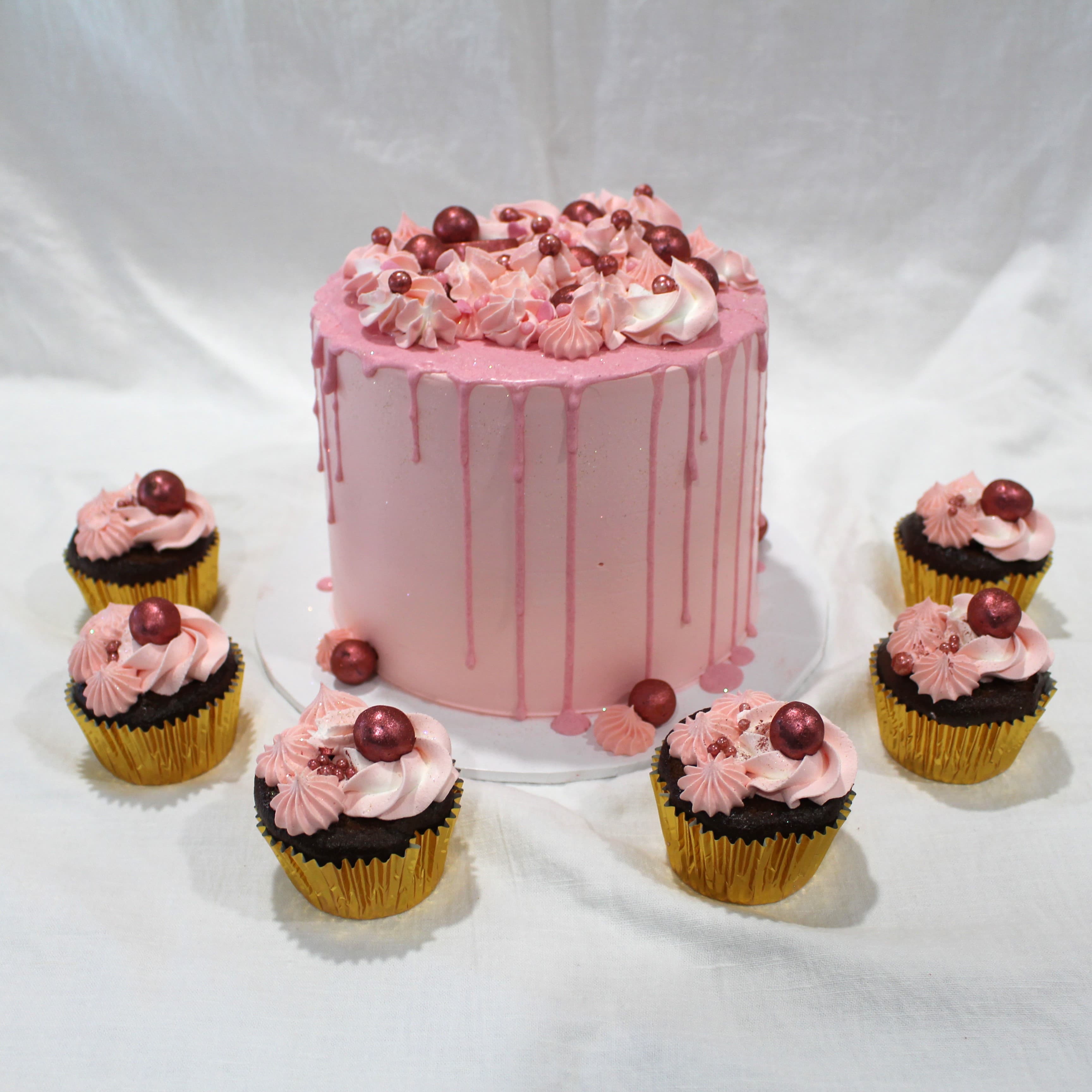 Pink drip celebration cake with matching gold-foil cupcakes